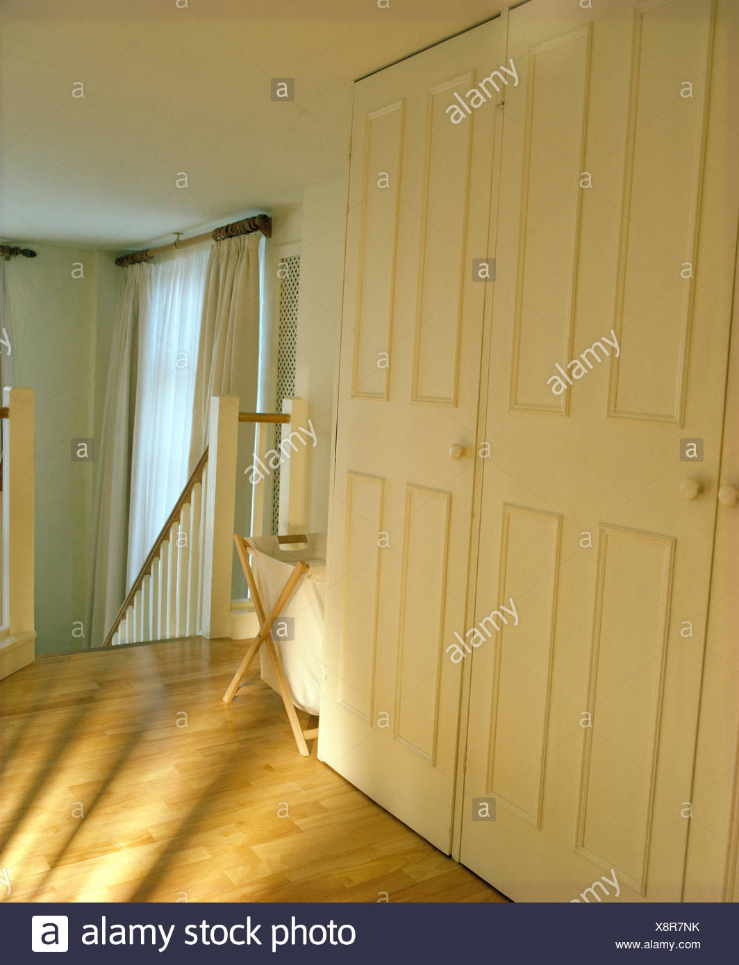Fitted Cream Painted Wardrobe And Wooden Flooring On Landing In