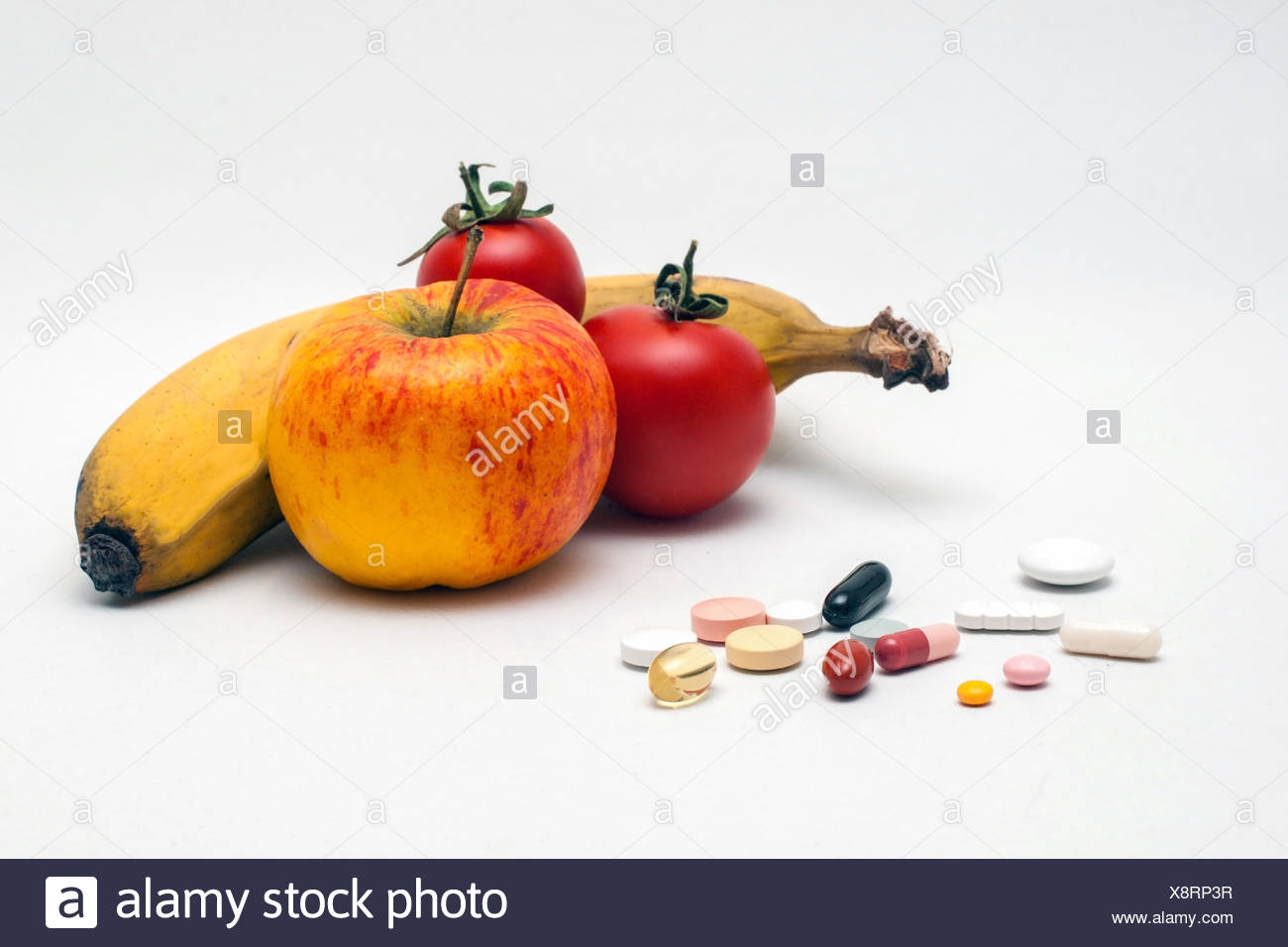verschiedene bunte Tabletten, Apfel, Banane und Tomaten, isoliert Stock Photo