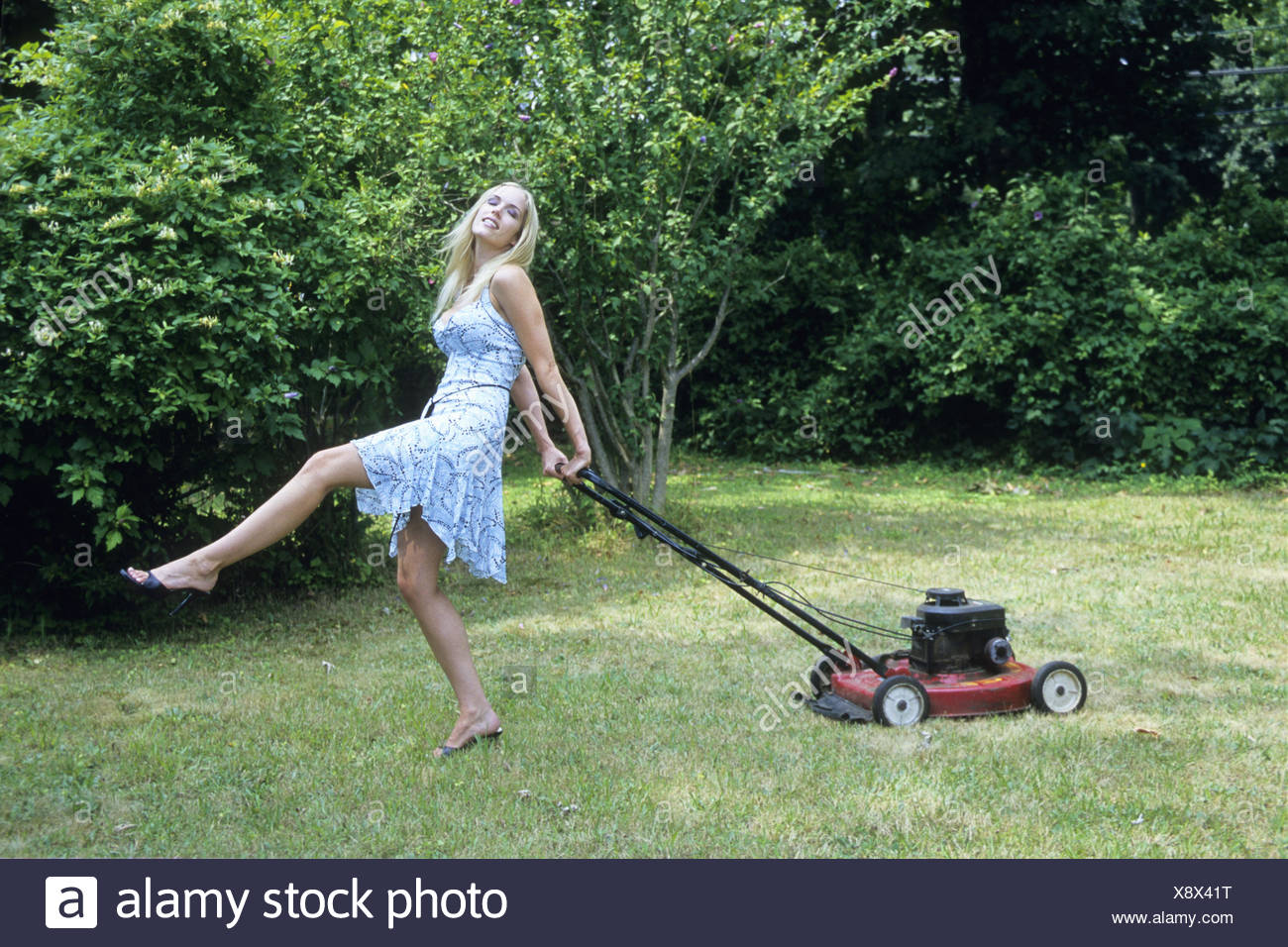 Mid Adult Woman Mowing Lawn. and. 