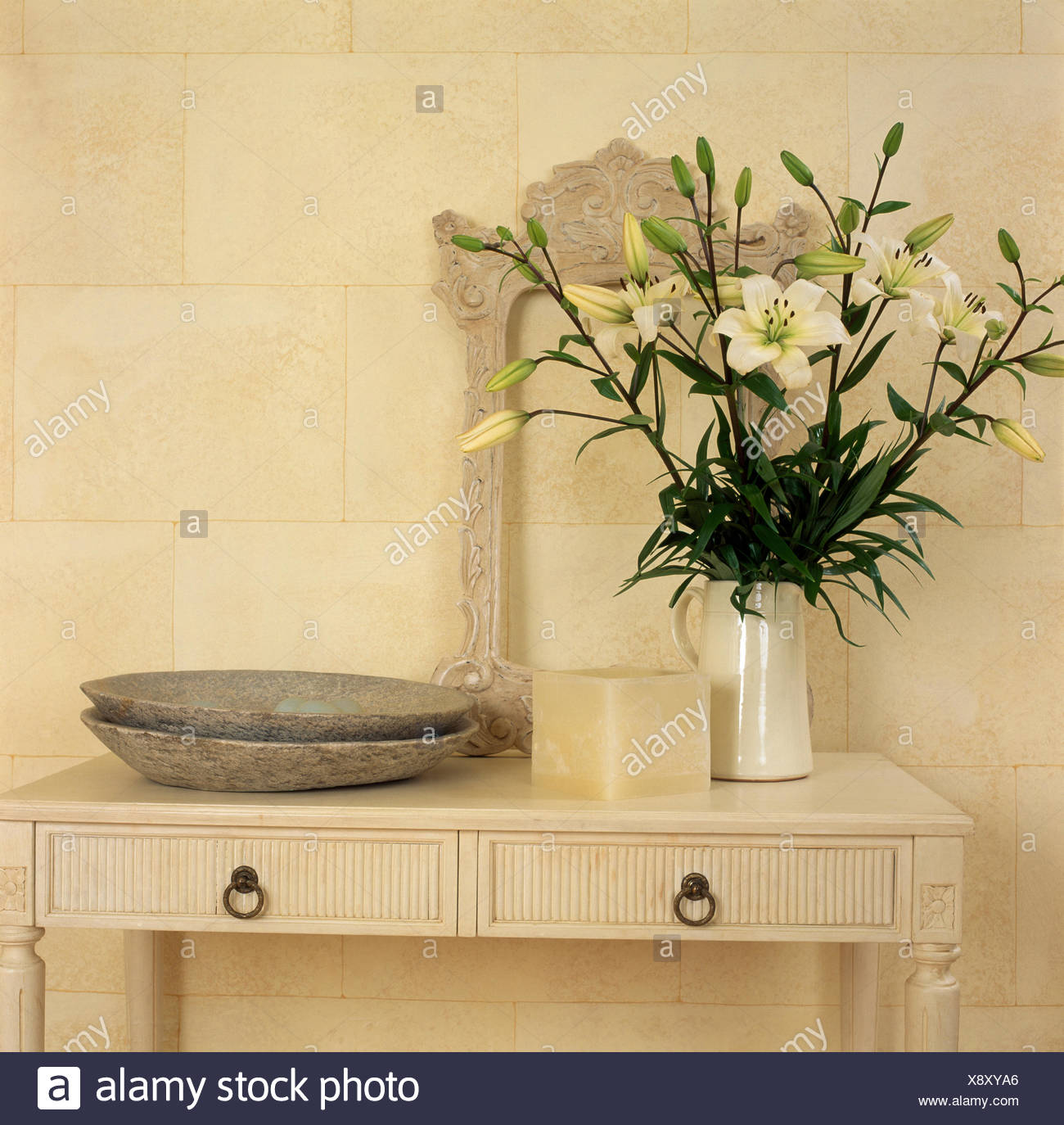 Vase Of White Lilies On A Cream Painted Table With Rustic Pottery