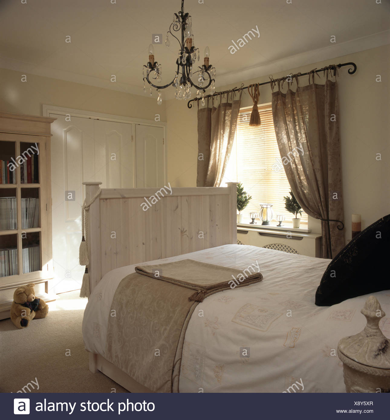 White Duvet And Cream Throw On A Lime Washed Wooden Bed In