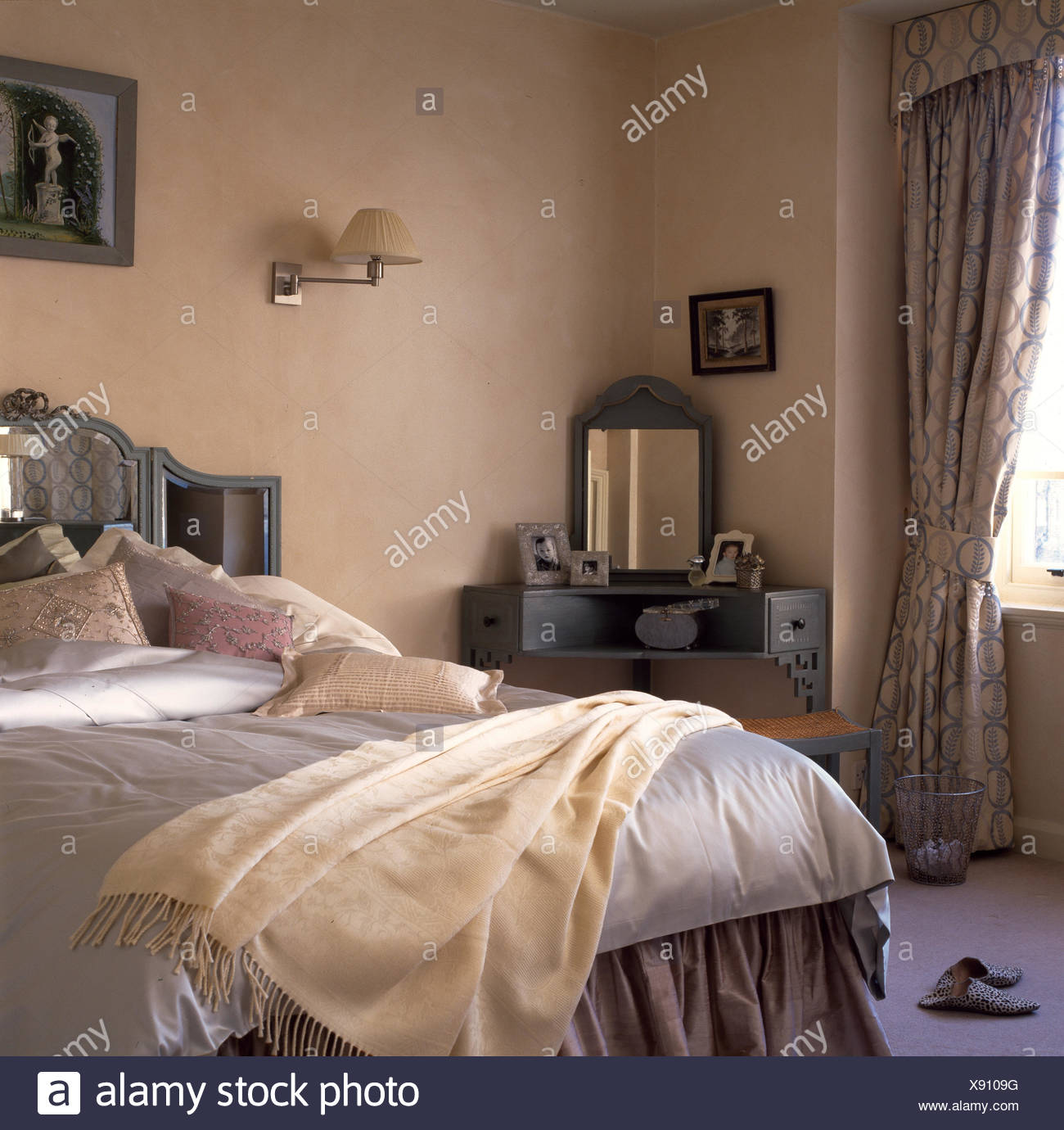 Dressing Table In Corner Of Bedroom With Cushions And Cream Throw On Bed With Mirrored Headboard Stock Photo Alamy