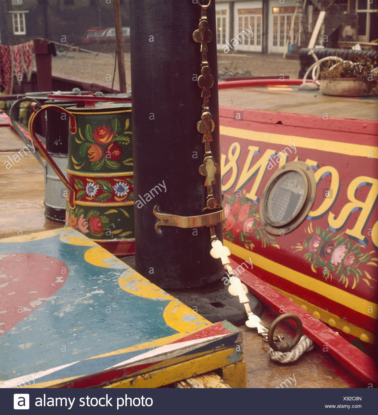 Close Up Of Black Chimney Stack And Decorated Tin Jugs On Cabin
