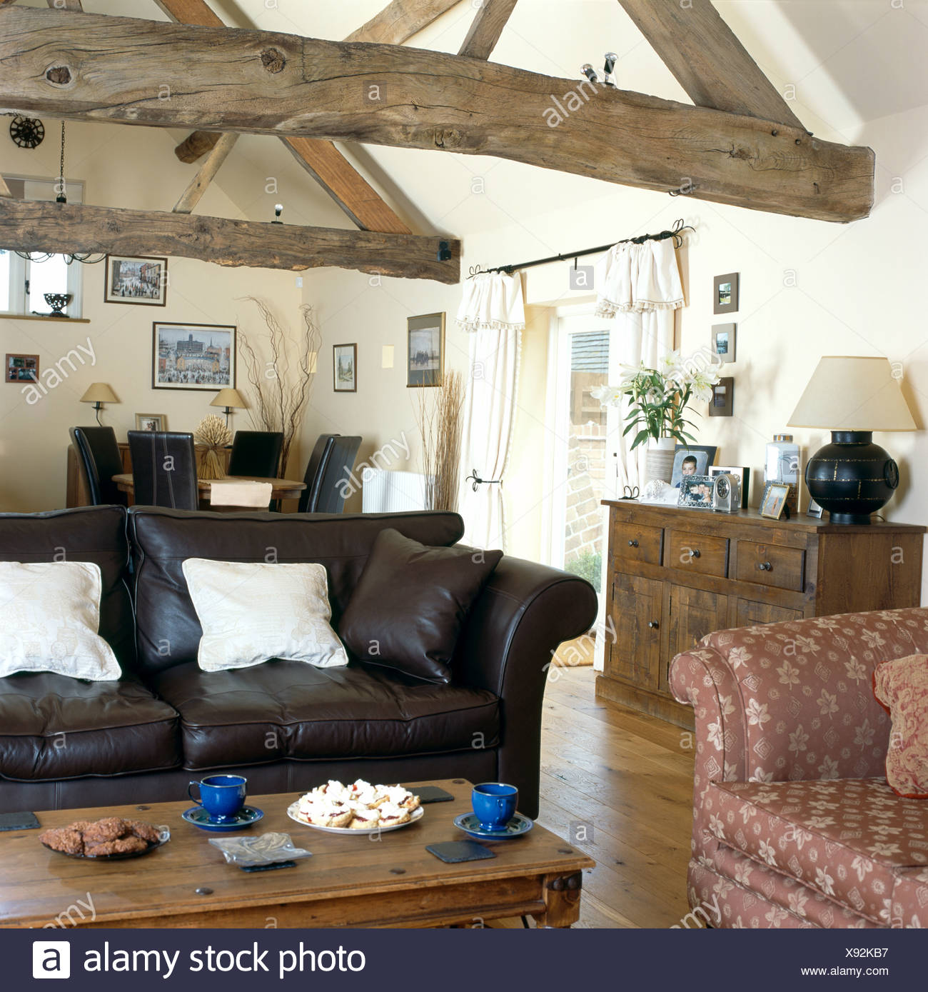 Black Leather Sofa And Old Wooden Chest In Country Living Room