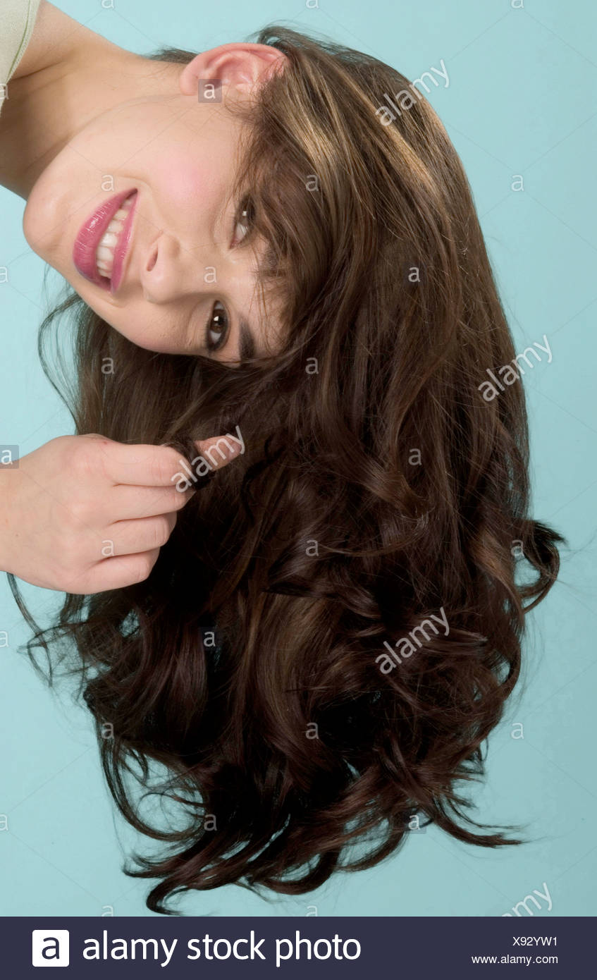 Female Long Brunette Curly Hair Wearing Pale Green Top Leaning