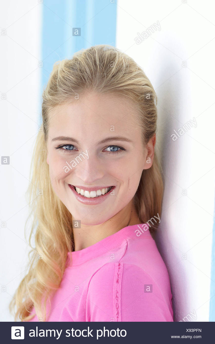 Female With Long Blonde Hair Wearing A Pink Top And Natural