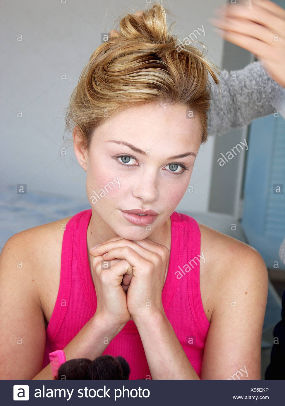 Female Blonde Hair Off Face Wearing Pink Vest Top Having Hair Put