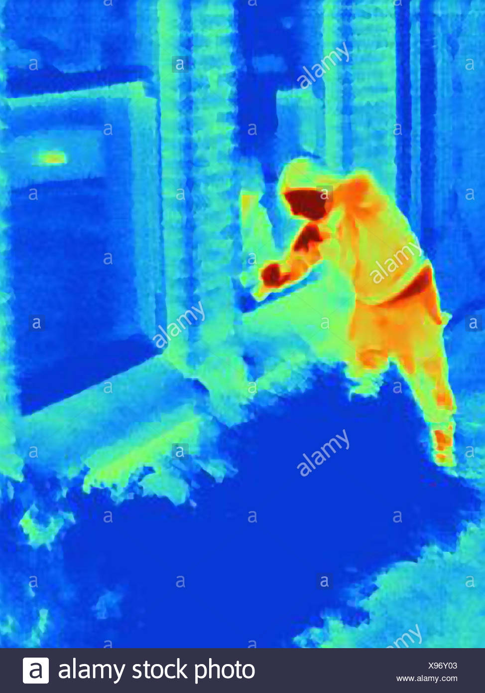 Thermal photograph of a burglar breaking into a house Stock Photo