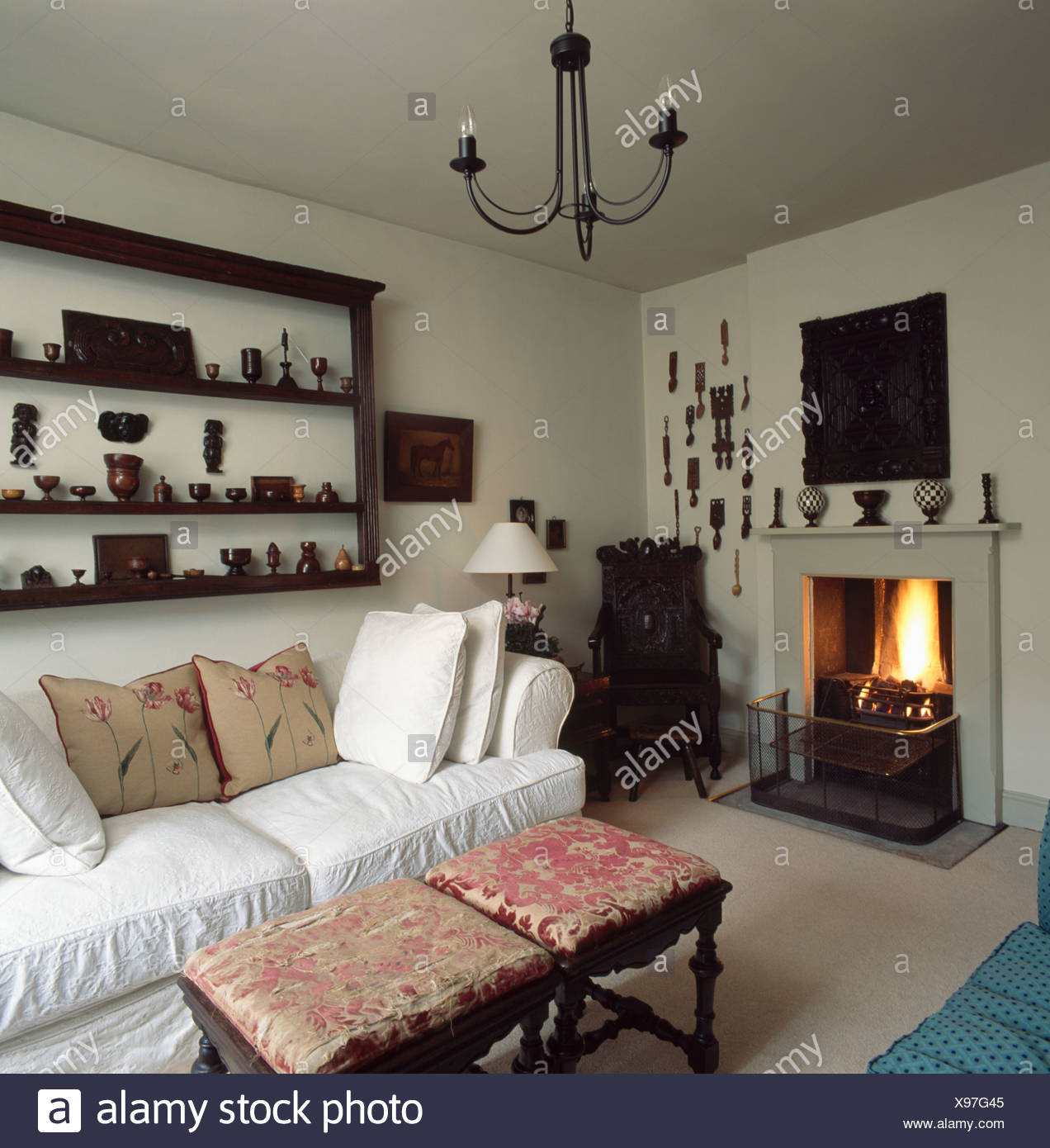 Collection Of Treen On Antique Shelves Above White Sofa In Country