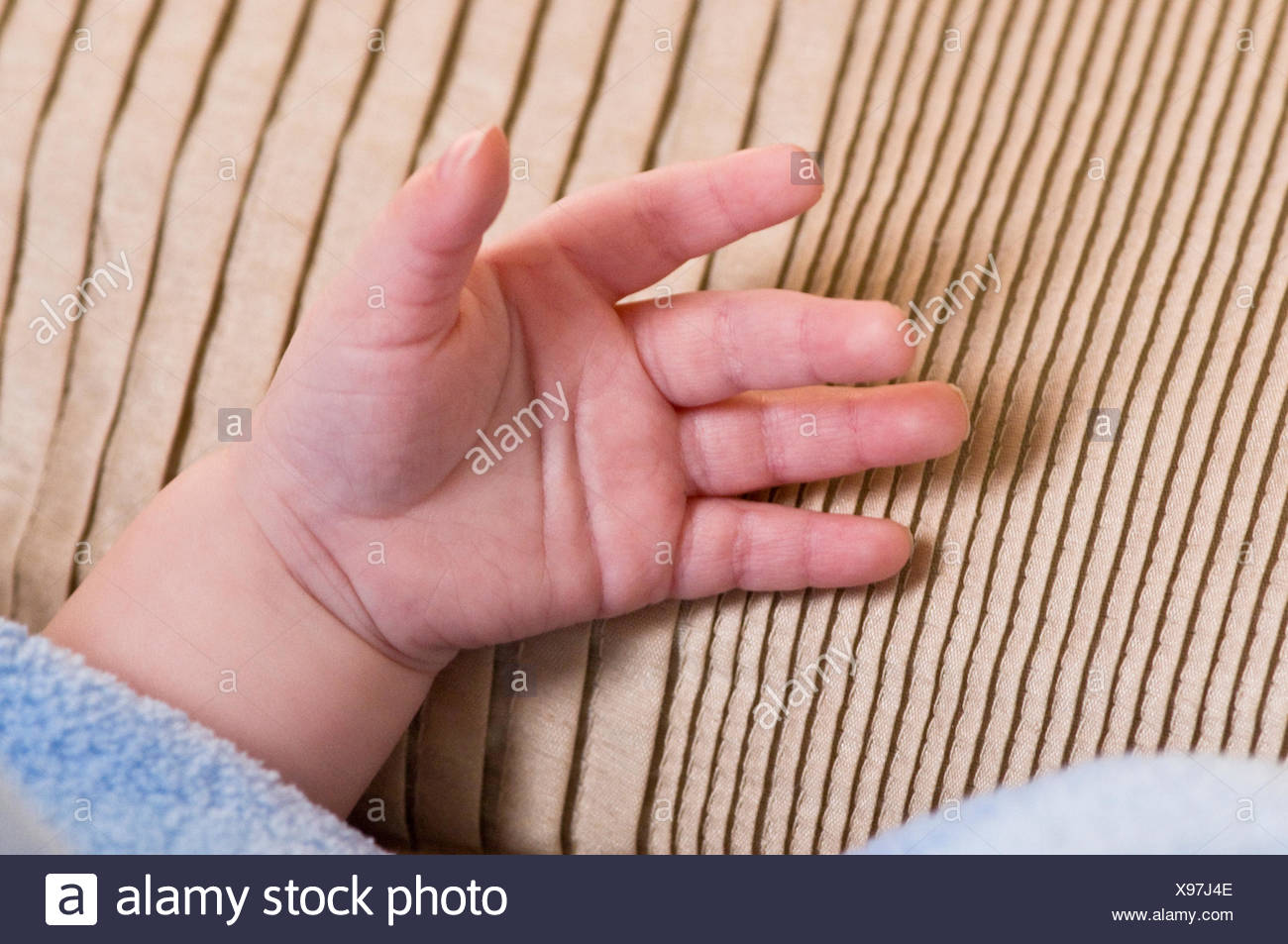 A Four Month Old Baby Places A Hand On A Pillow Stock Photo