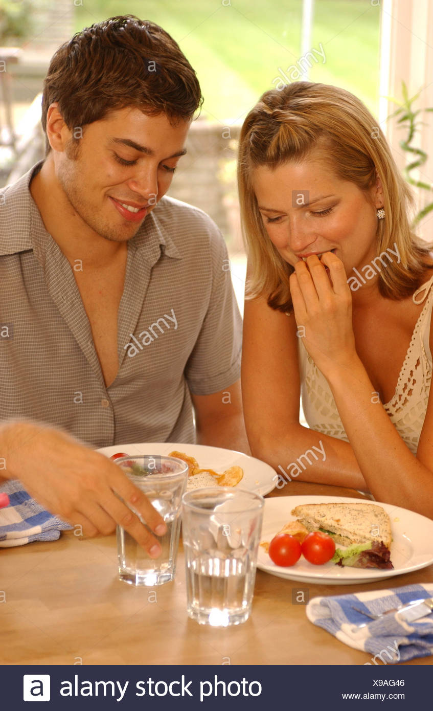 Couple Sitting At Kitchen Table Semi Profile Of Female On Left