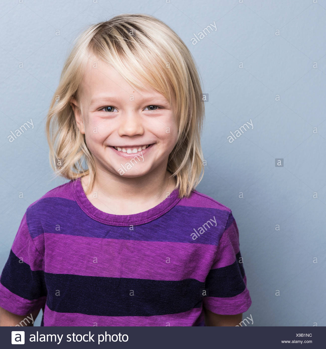 Portrait Of Blonde Haired Boy Looking At Camera Smiling Stock
