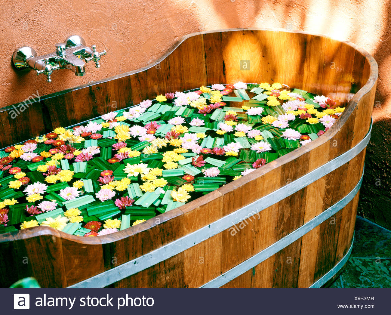 A Wooden Bathtub Filled With Flowers And Aromatic Herbs In