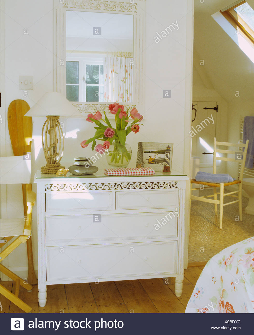 White Mirror On Wall Above White Painted Chest Of Drawers With