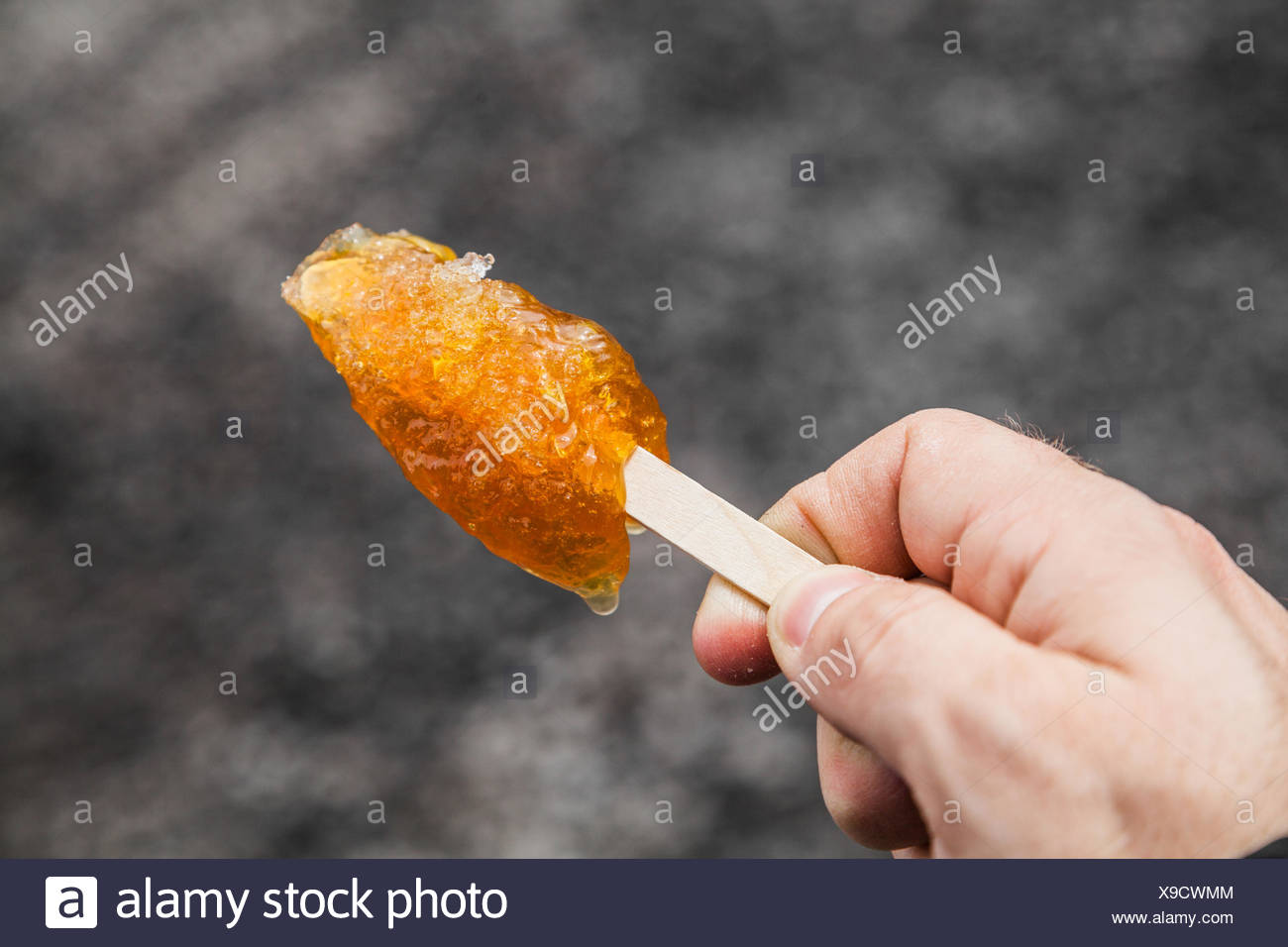 Hand Holding Maple Taffy On A Wood Stick Stock Photo Alamy