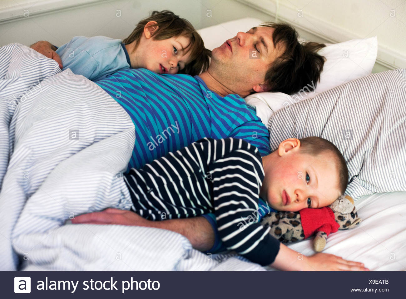 family of three people sleeping in one bed stock photos family of