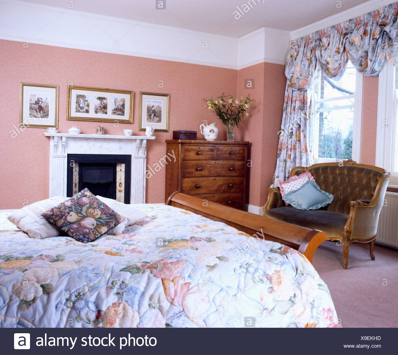 Peach Bedroom With Matching Floral Curtains And Quilt Stock