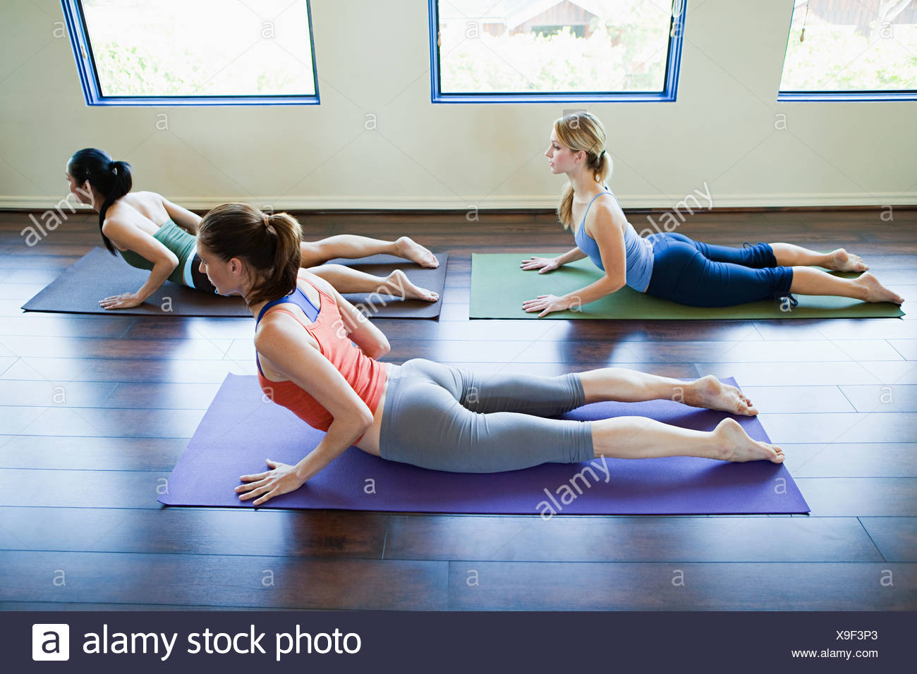 Three Woman Doing Cobra Pose In Yoga Class Stock Photo Alamy