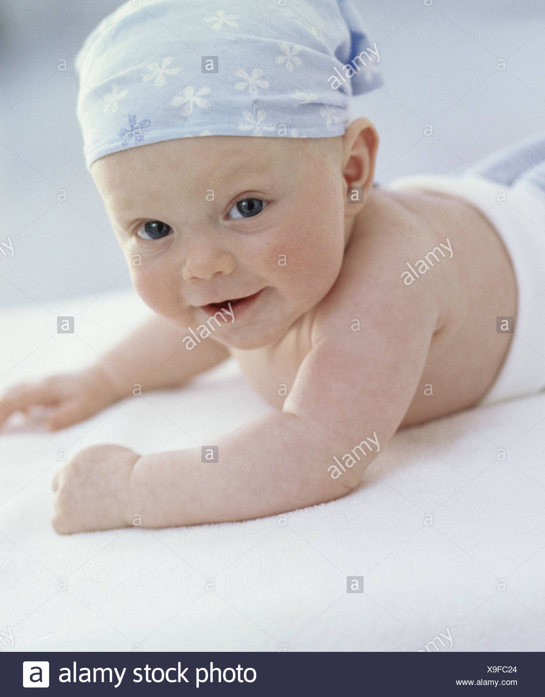 Baby Lie Caps Headscarf Half Portrait View Camera Child Small 5 Months Infant Colour Of Eyes Blue Abdominal Position Head Lift Carefully Smile Mischievously Plastic Pants Curled Inside Conception Development Childhood Innocence