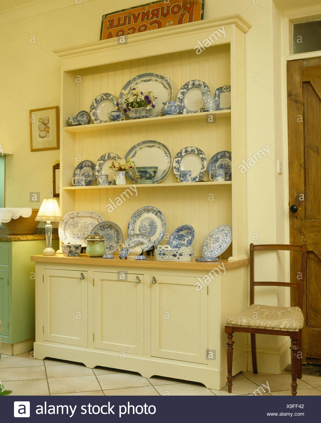 Rush Seated Chair Beside Large Cream Dresser With Collection Of
