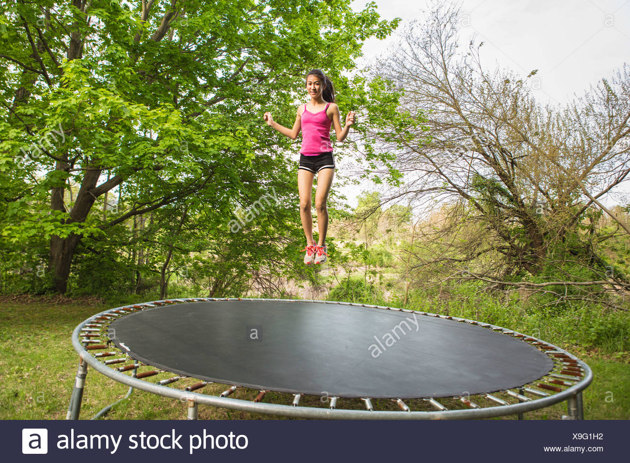 Young Girl Jumping On Trampoline High Resolution Stock Photography and
