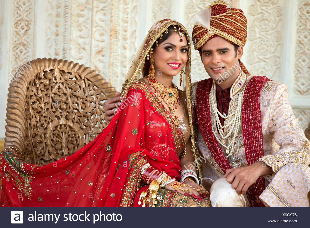 Indian Bride And Groom In Traditional Wedding Dress Sitting On A