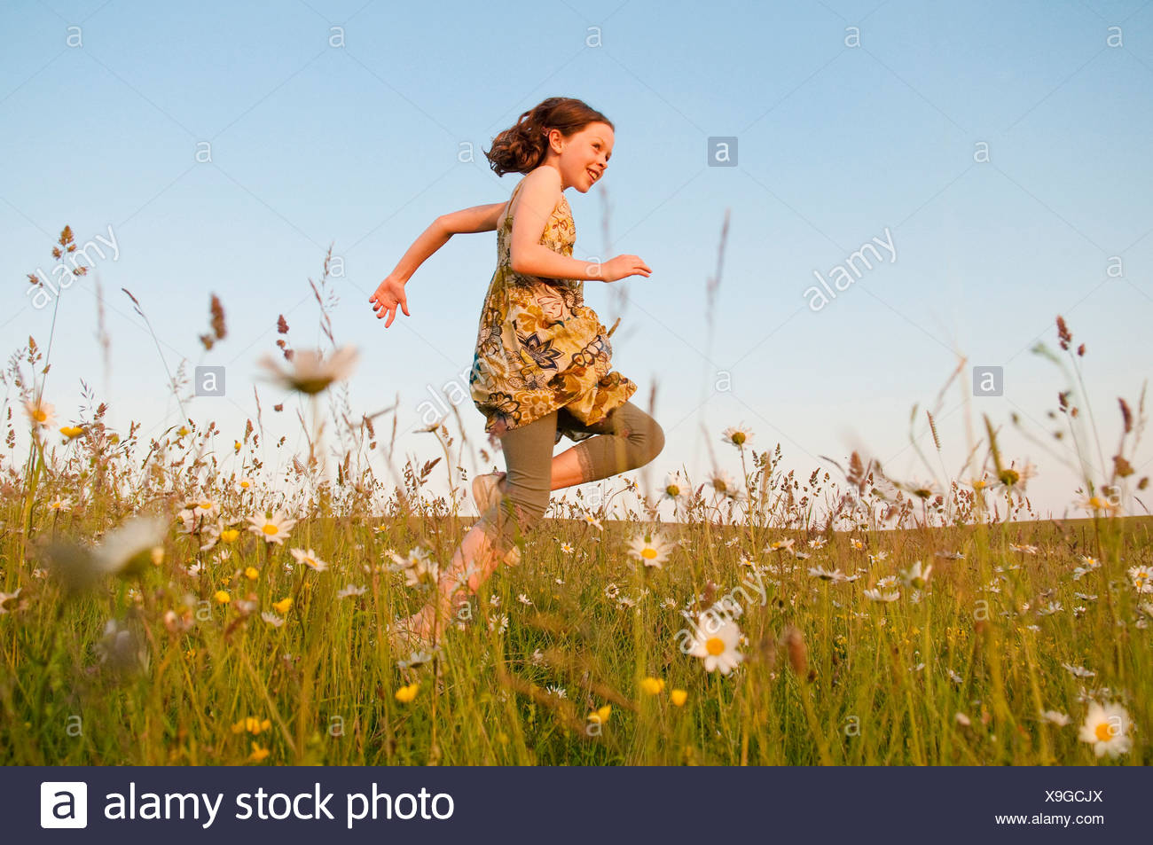 Girl Running In Field Of Flowers Stock Photo Alamy