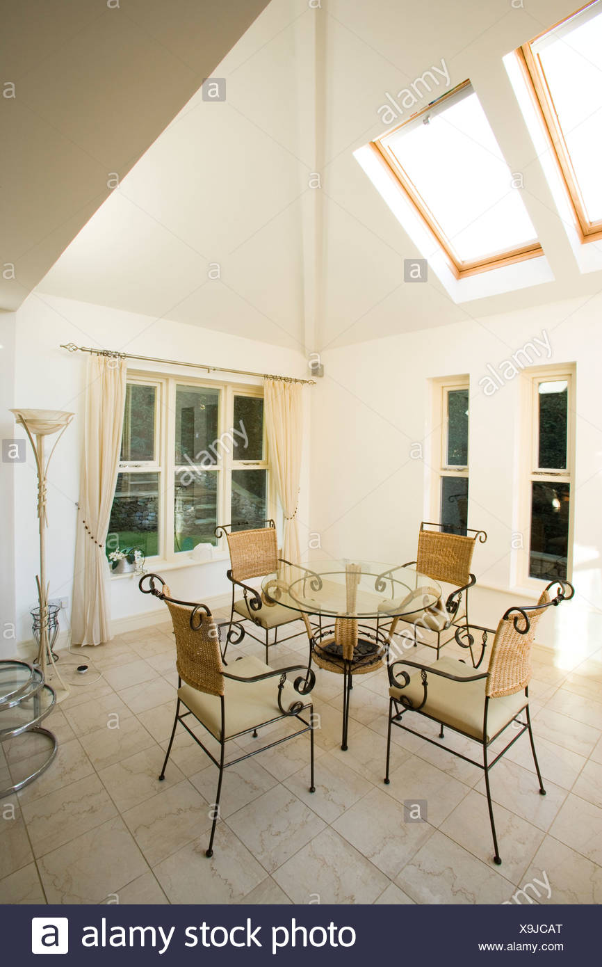 Table And Chairs In A Well Lit Room With Roof Velux Windows