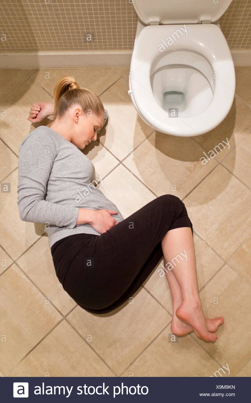 Model Released Pregnant Woman Lying On Bathroom Floor By Toilet