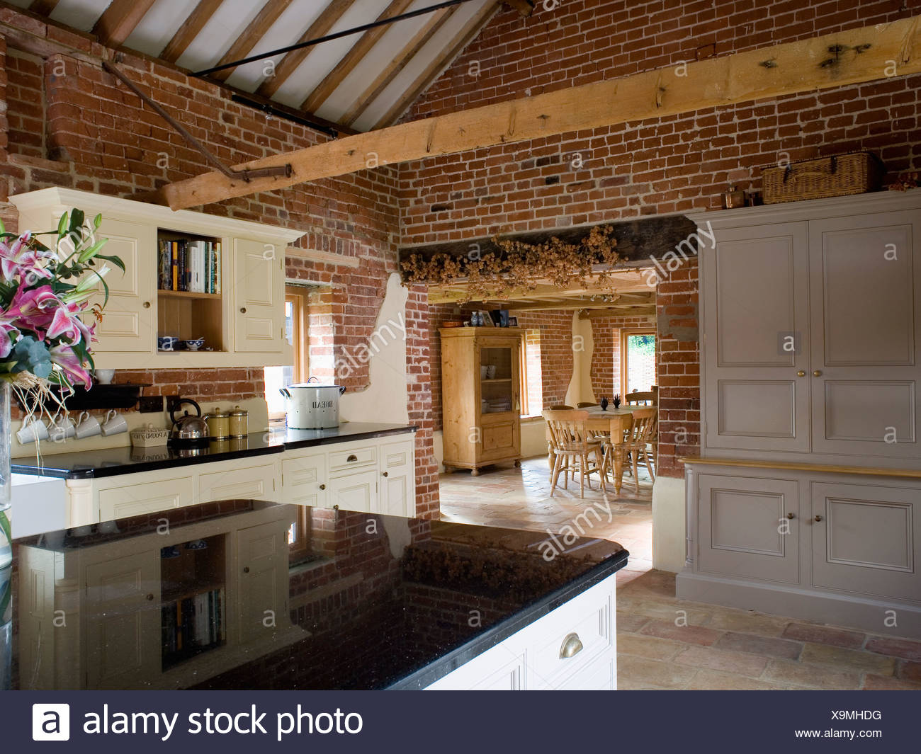 Dresser Beside Open Doorway In Large Barn Conversion Kitchen With