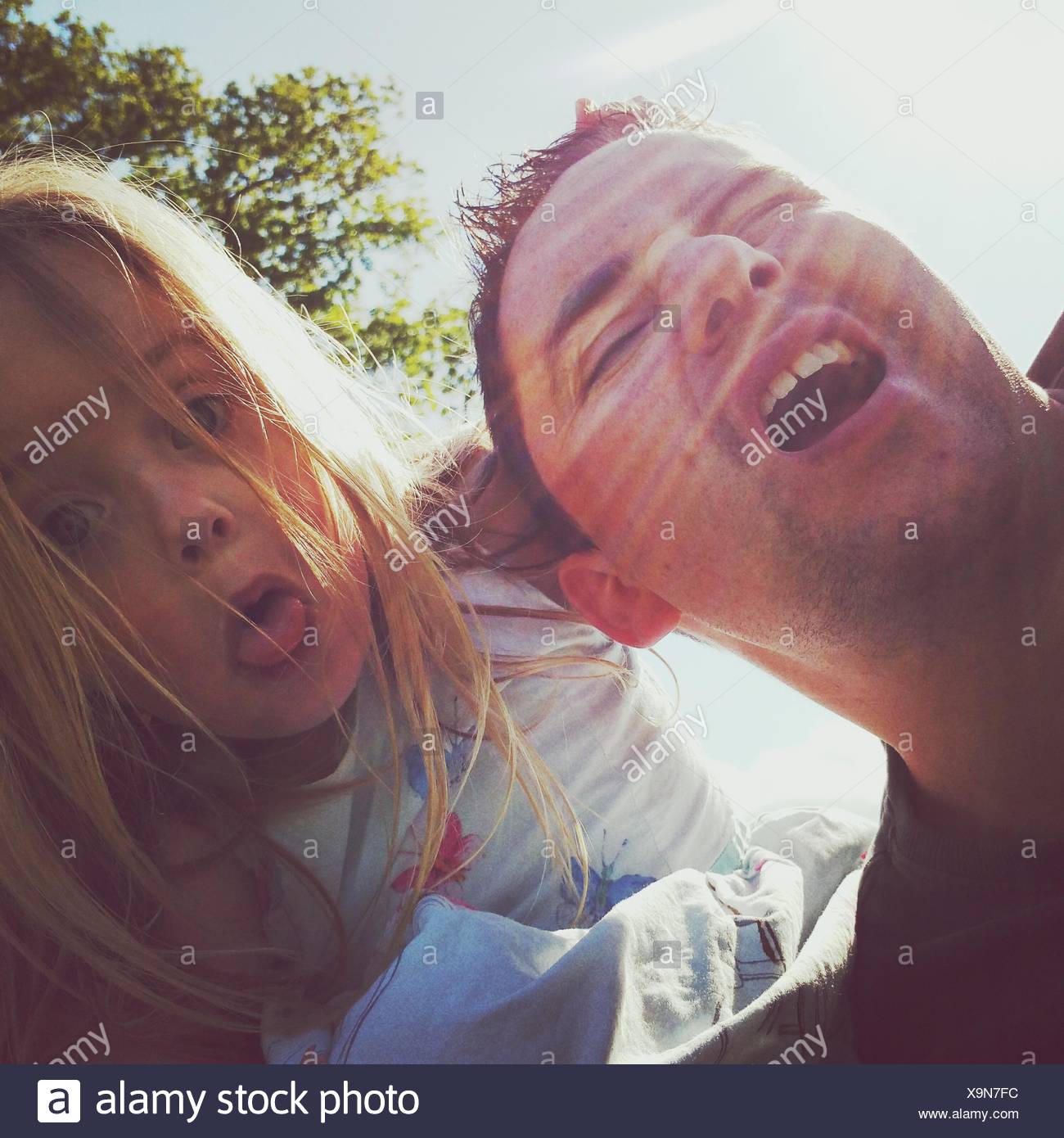 Cute Daughter With Dad Against Sky Stock Photo