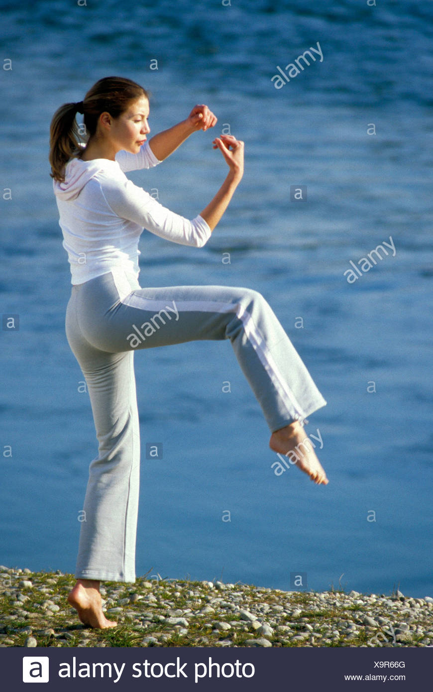 Female Brunette Hair In Pony Tail Wearing Grey Tracksuit Bottoms