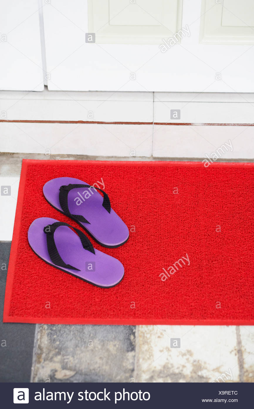 High Angle View Of A Pair Of Flip Flop On A Doormat Stock