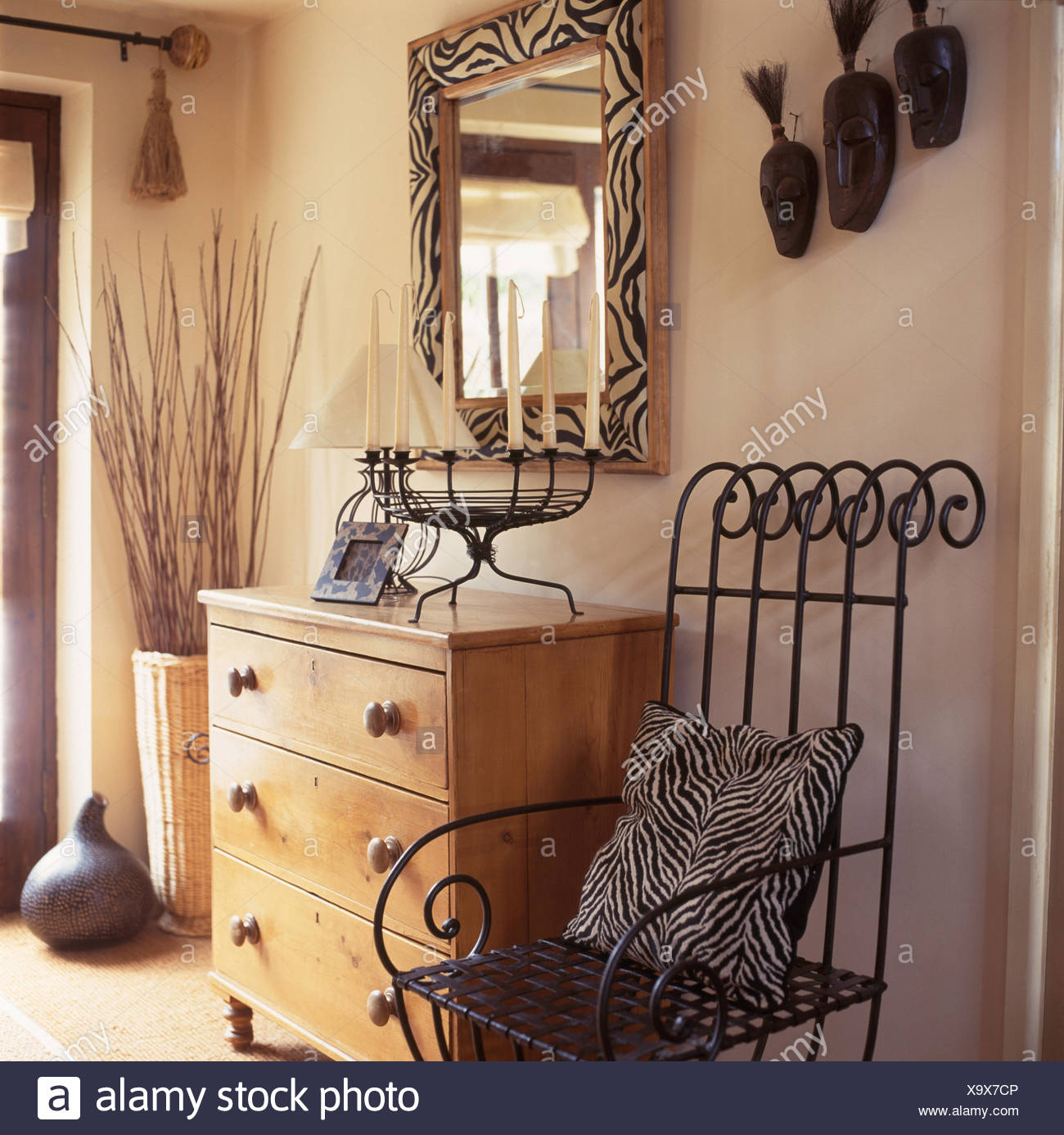 Wrought Iron Chair With Zebra Print Cushion Beside A Pine Chest Of