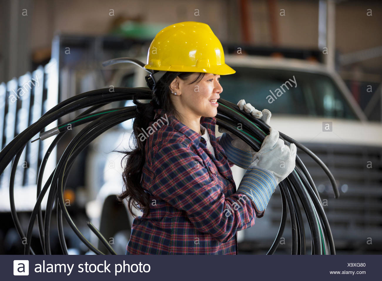 Female Power Engineer With Power Cable In Service Garage Stock