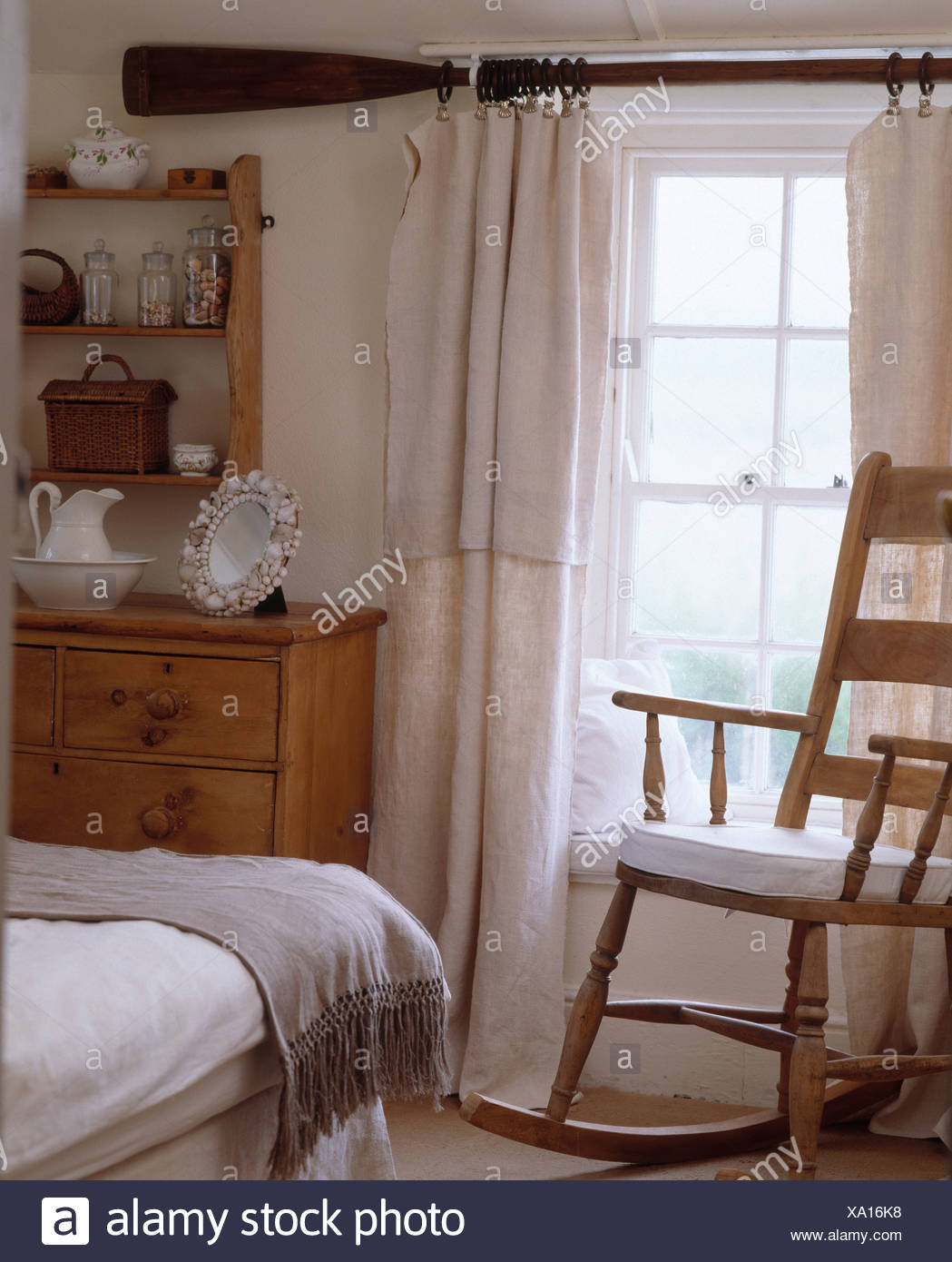 Rocking Chair In Front Of Window With Old Oar Used As Curtain Rod