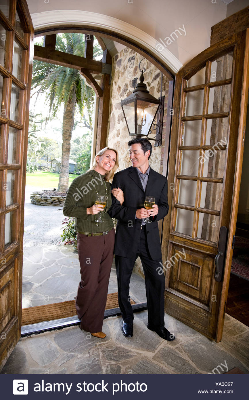 Interracial Couple Drinking Wine Walking Through Front Door