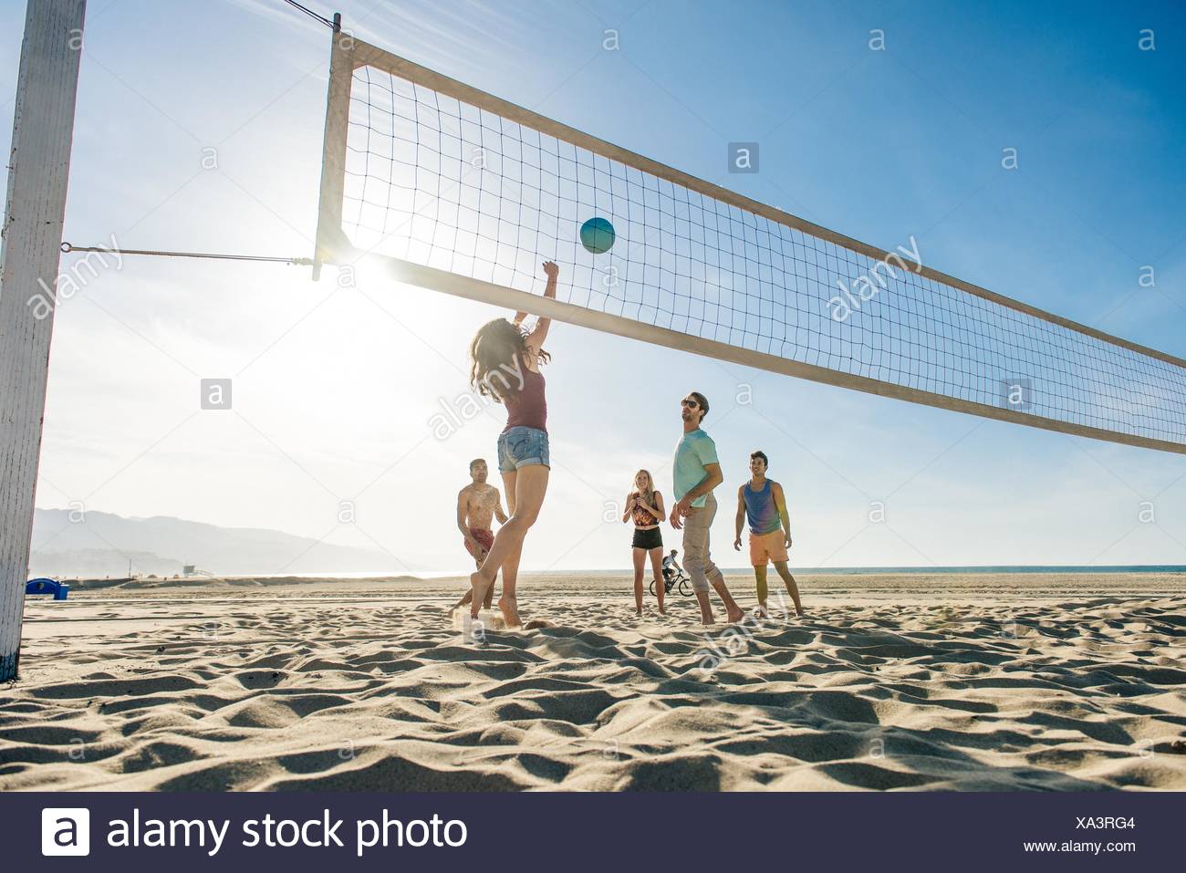 Group of friends playing volleyball on beach Stock Photo