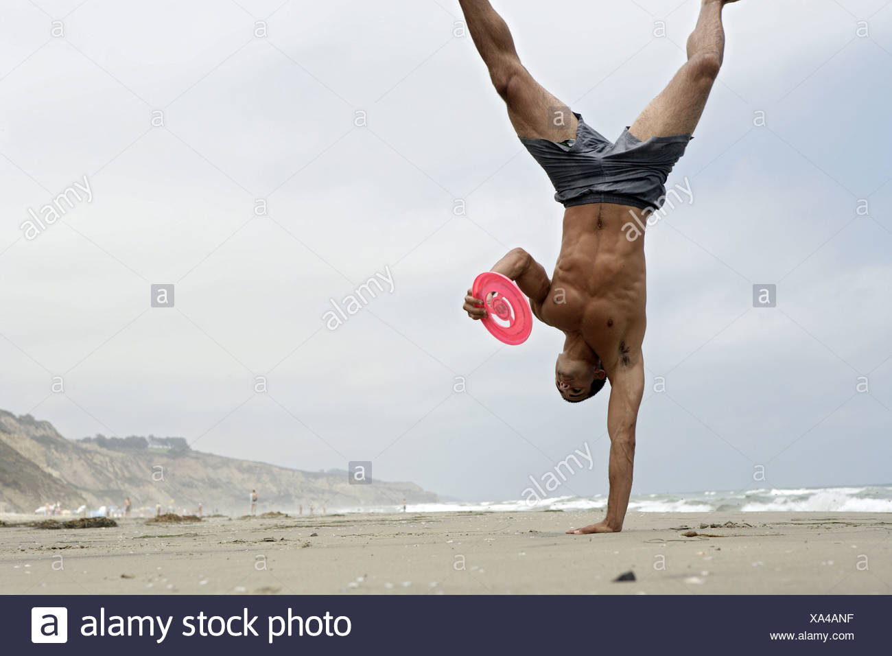 A person performs gymnastic on a beach. Stock Photo