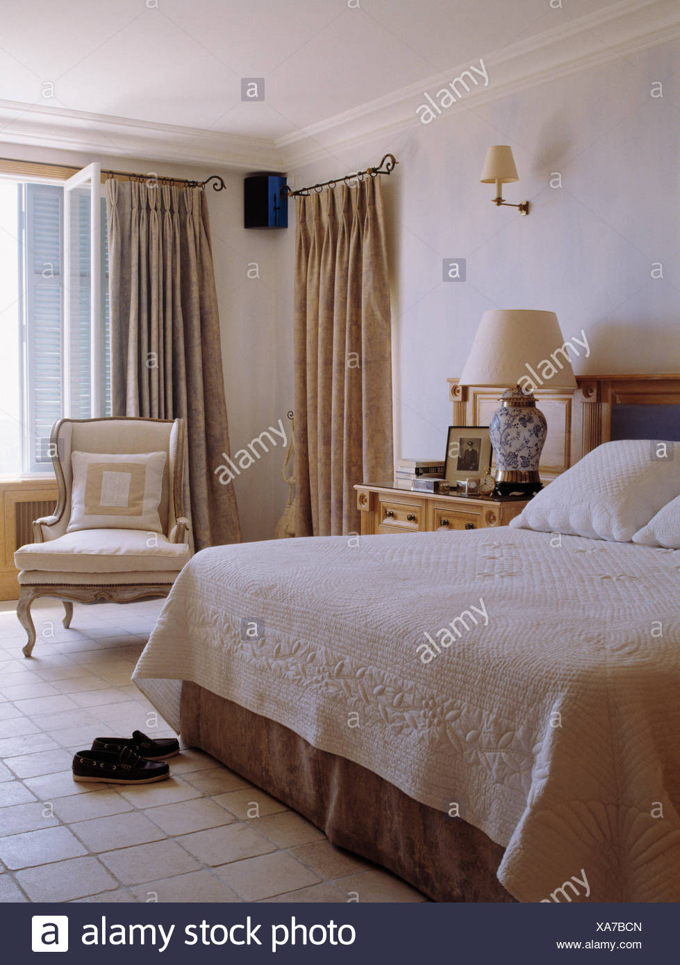 White Quilt On Bed In French Coastal Bedroom With Cream