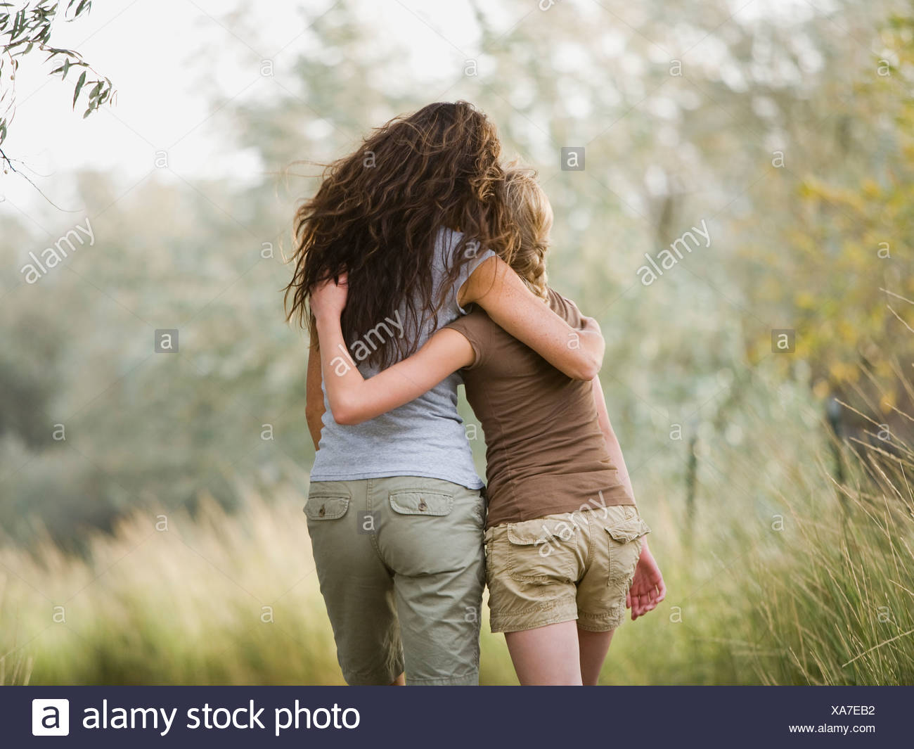 Woman And Young Woman Walking With Arm Around Each Other Stock Photo Alamy