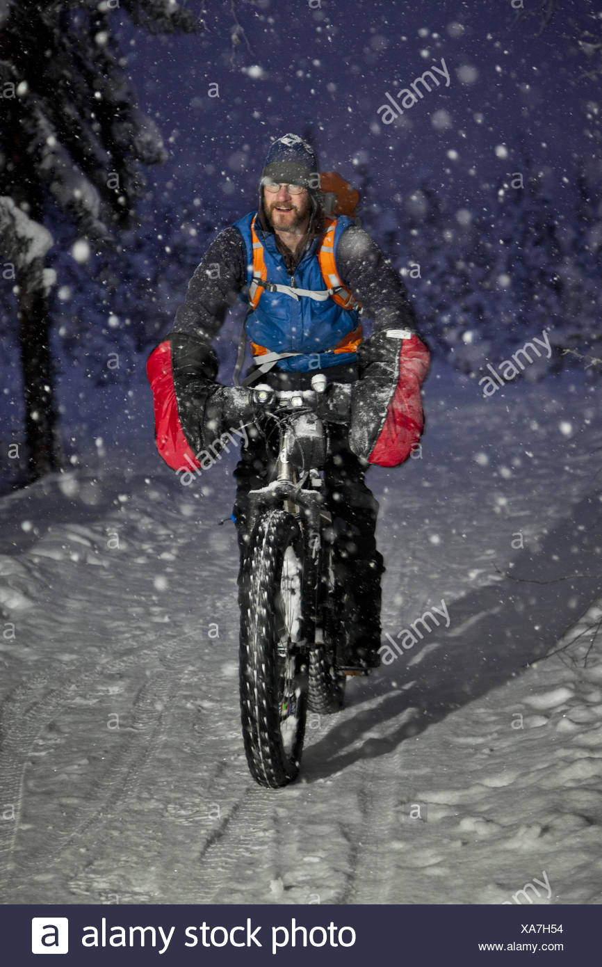Winter Cyclist Riding His Fatbike On The Chester Creek Trail In Winter Cyclist Riding His Fatbike On The Chester Creek Trail In Anchorage Southcentral Alaska