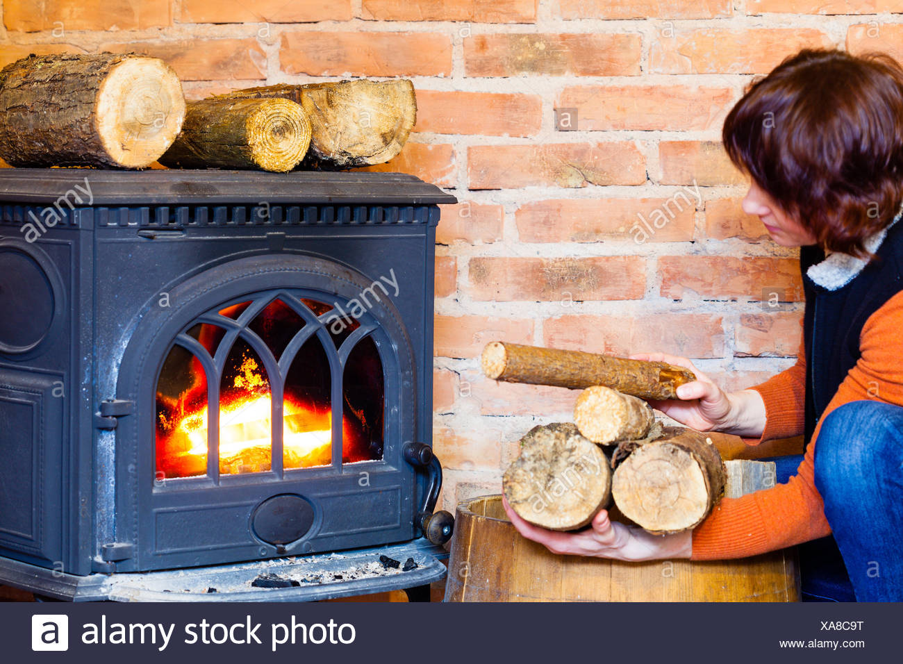Winter At Home Woman Putting Some More Wood On Fire Fireplace