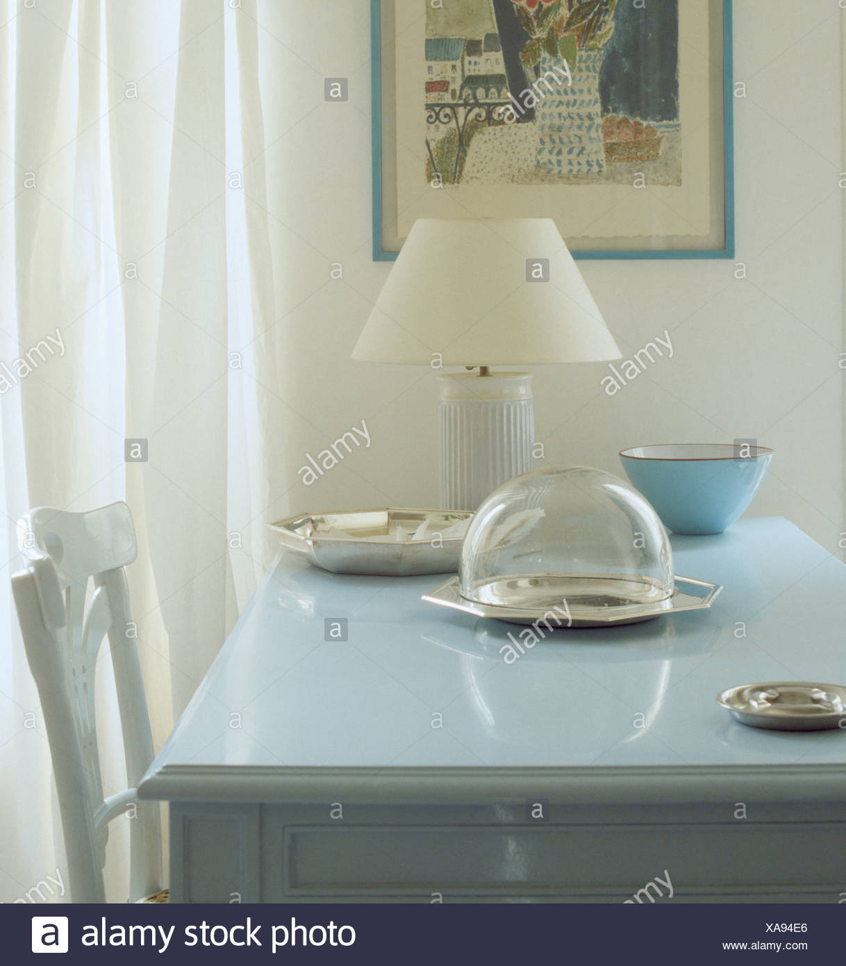 White Lamp And Glass Dome On Pastel Blue Wooden Table In