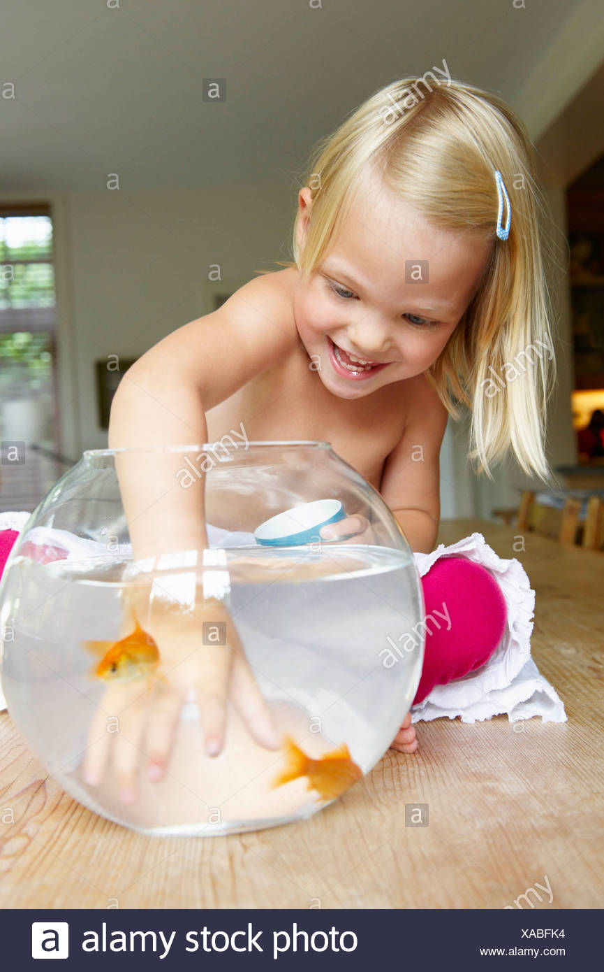Girl Trying To Catch A Fish In A Bowl Stock Photo Alamy