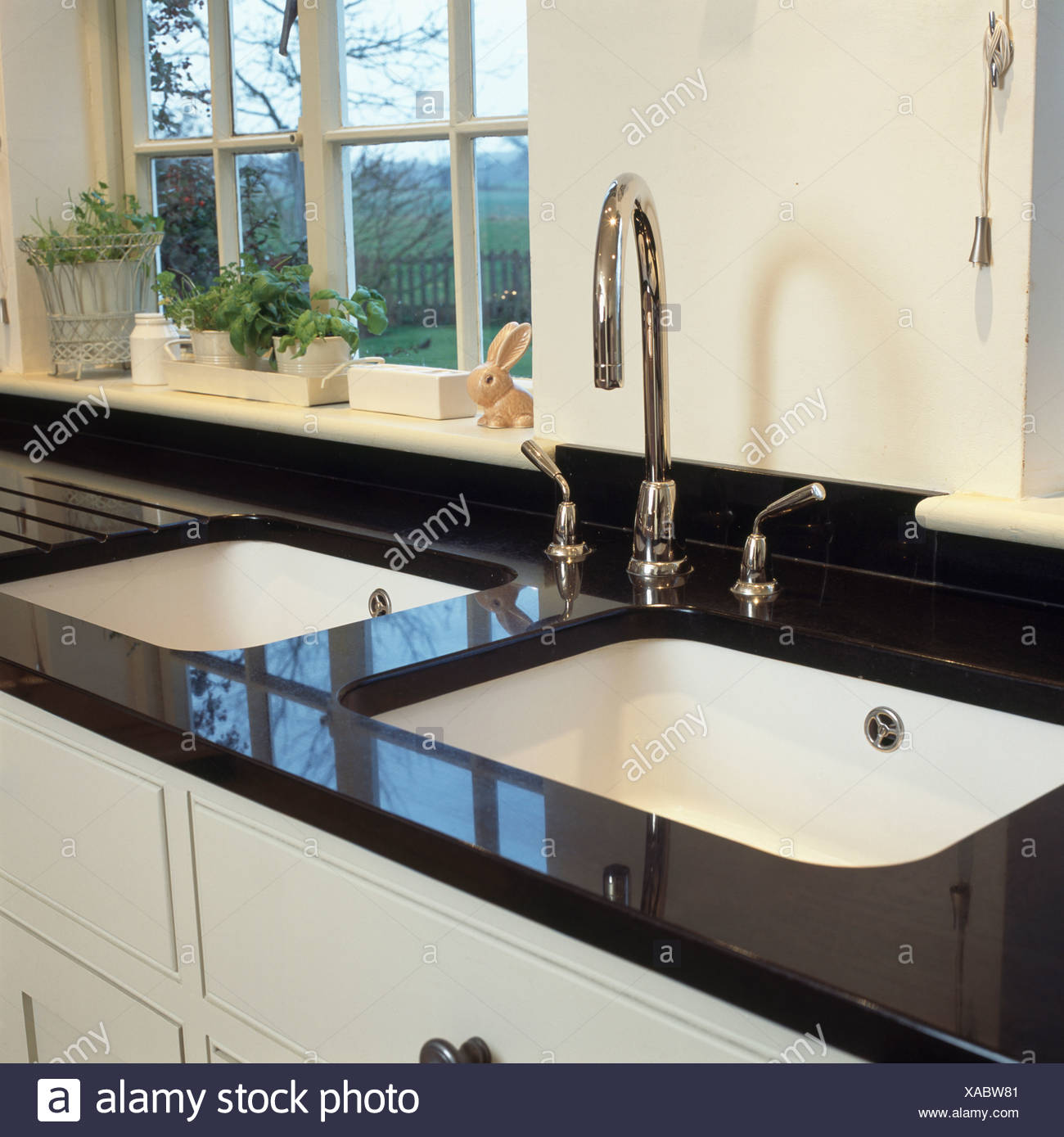 Double White Sinks And Chrome Taps In Black Granite Worktop Below