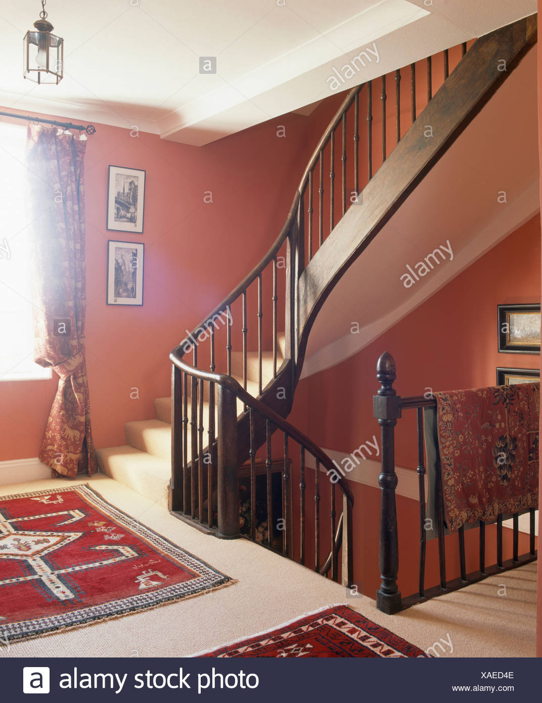 Dark Wood Banisters On Staircase In Red Landing With Persian Rugs