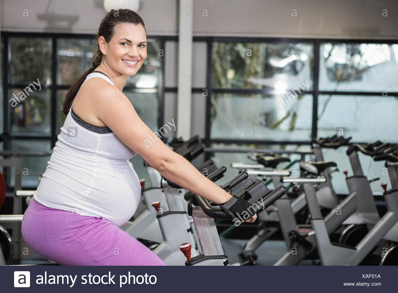 Woman Pregnant Riding Bike Side Stock Photos & Woman Pregnant Riding