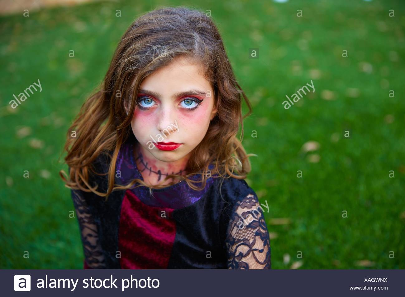 Halloween makeup kid girl blue eyes in outdoor backyard lawn