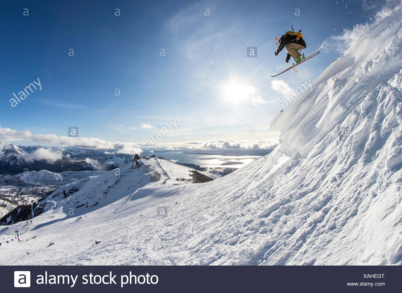 A Skiers Jumps Off A Cornice And Catches Air On A Sunny Bluebird